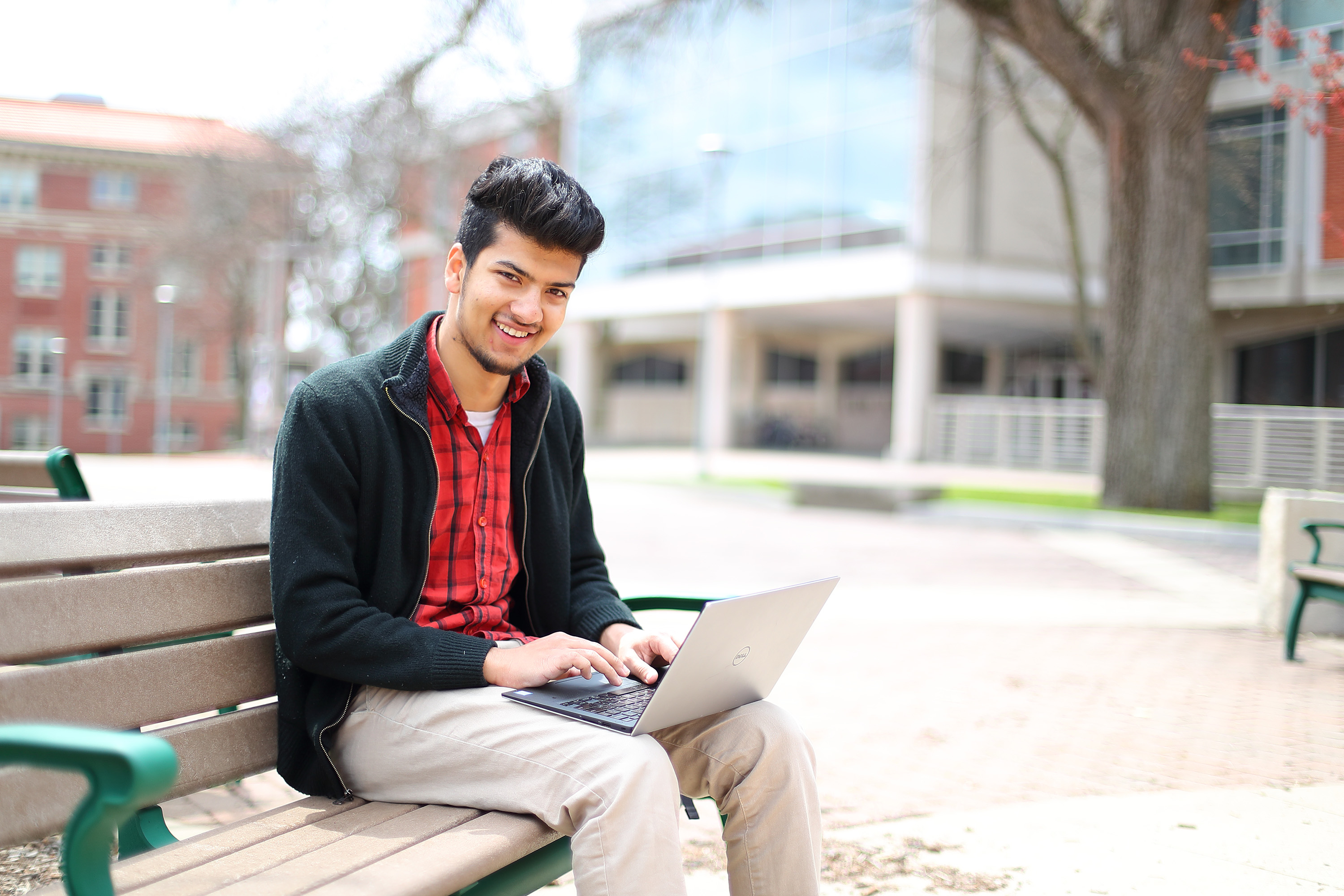 Smiling student sitting on bench outside